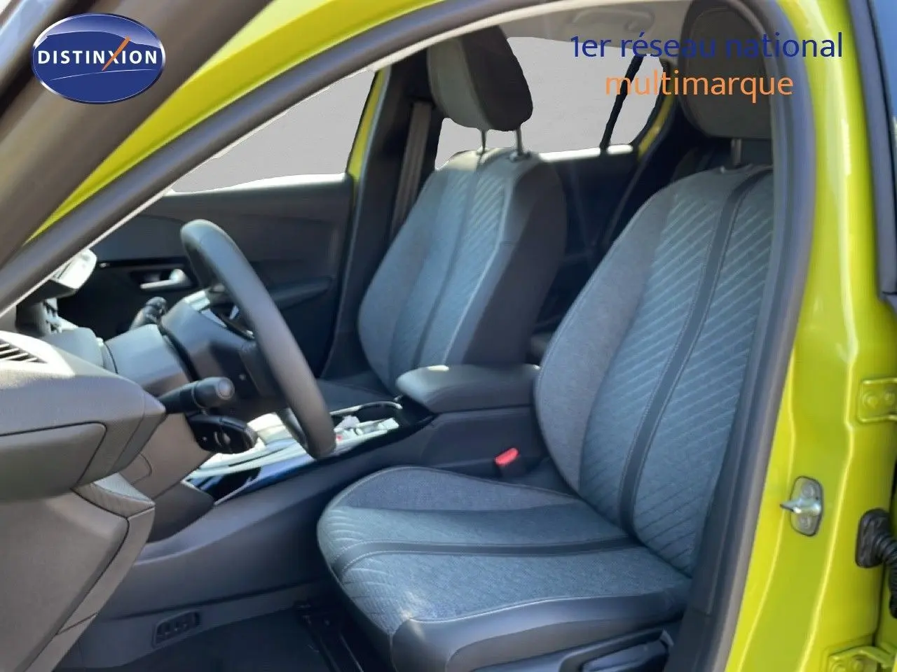 Vue intérieure côté conducteur de la Peugeot 208 Hybrid jaune Agueda, sièges tissu gris avec détails noirs.