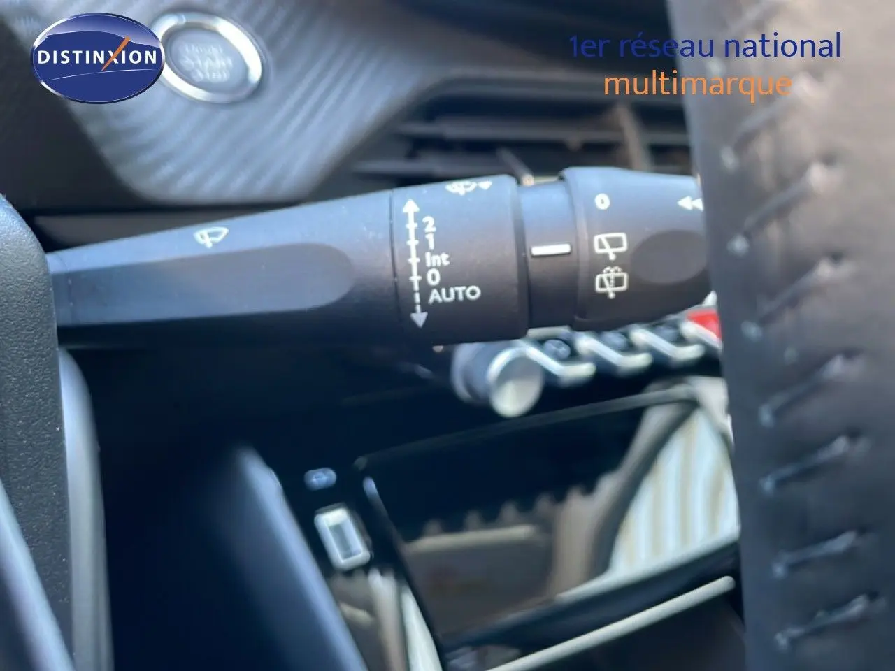 Gros plan sur la commande d’essuie-glace à gauche du volant dans l’habitacle d’une Peugeot 208 jaune Agueda Metal.
