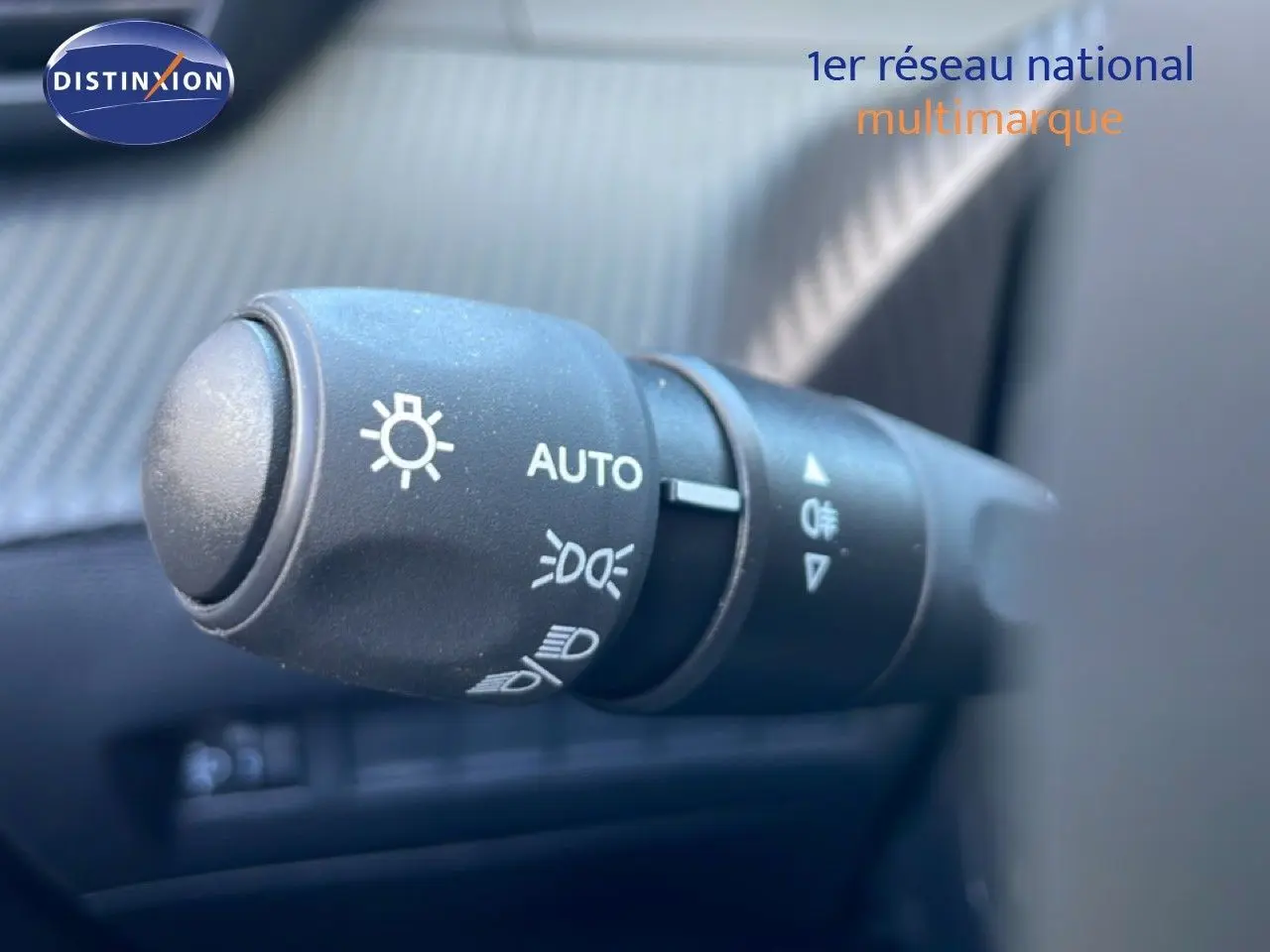 Gros plan sur la commande des phares du Peugeot 208 jaune Agueda Metal, avec réglage automatique visible.