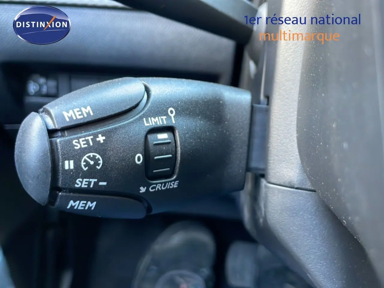 Gros plan sur la commande de régulateur de vitesse dans l’habitacle d’une Peugeot 208 jaune Agueda Metal 2026.