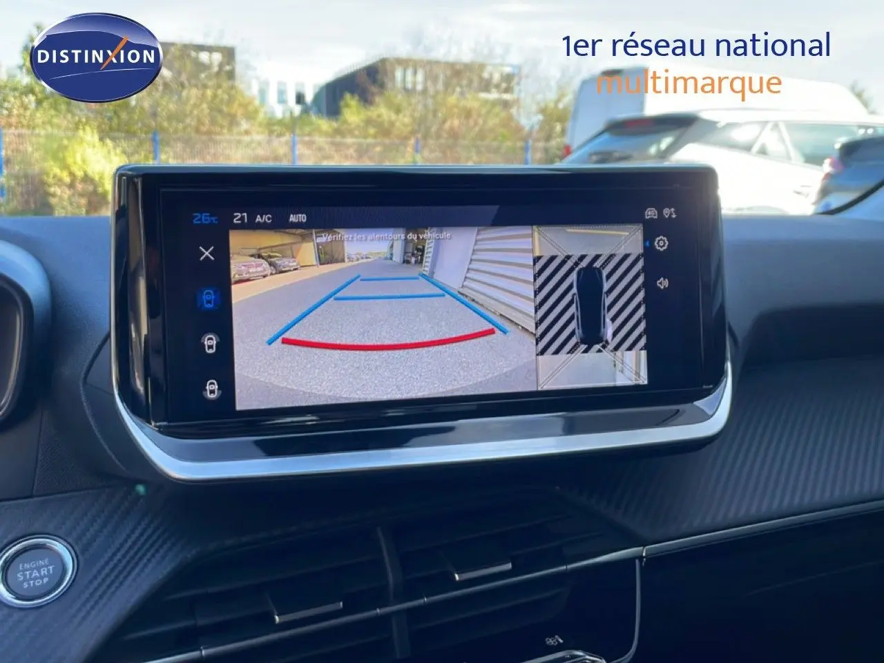 Écran tactile intérieur montrant la caméra de recul et l’aide au stationnement d’une Peugeot 208 jaune Agueda Metal.
