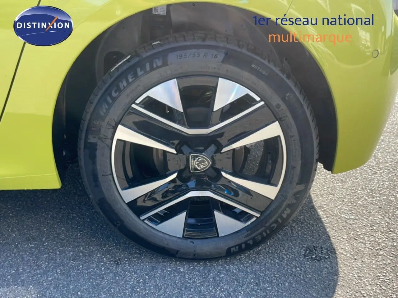 Gros plan sur la roue avant droite d'une Peugeot 208 Hybrid jaune Agueda Métal avec jante alliage noire et argent.