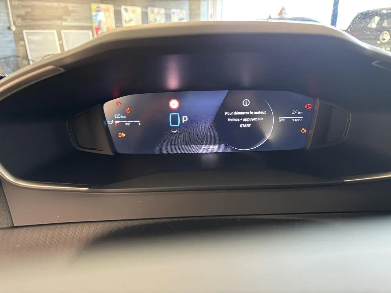 Vue rapprochée du combiné numérique 10 pouces du Peugeot 2008 Hybrid 2026 affichant les alertes et la vitesse à l'arrêt.