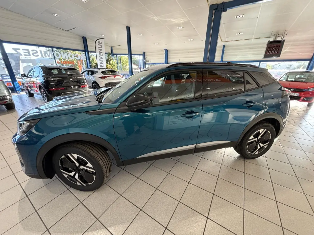 Peugeot 2008 bleu en vue de profil côté gauche dans un showroom lumineux avec jantes alliage bi-ton.