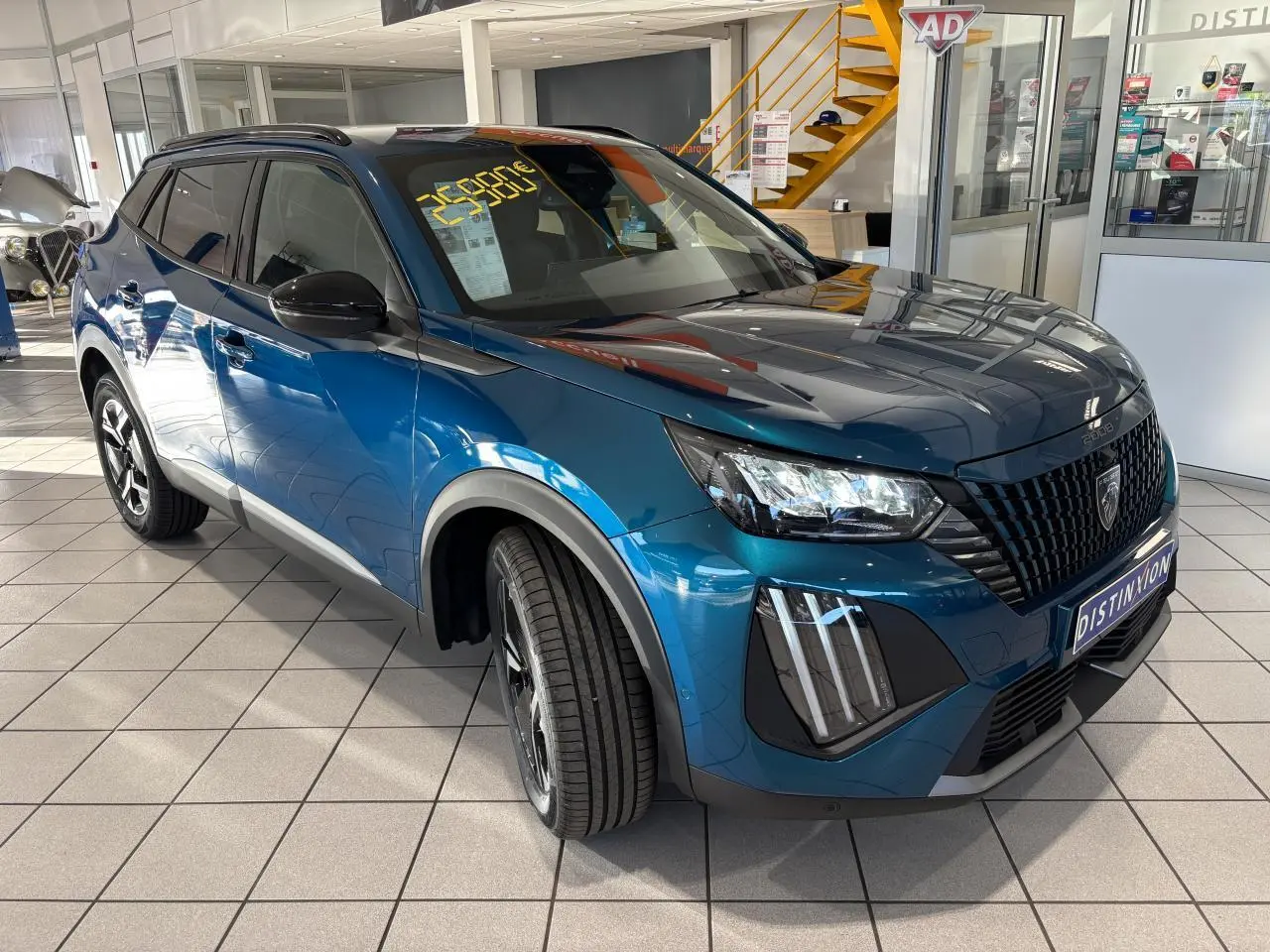 Peugeot 2008 hybride bleu en 3/4 avant droit, avec calandre noire et jantes alliage bi-ton 17 pouces.