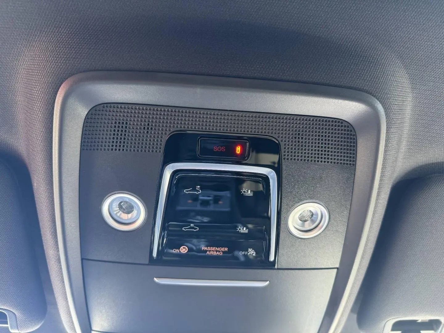 Vue en plongée sur le panneau de commande intérieur noir avec éclairage SOS et indicateurs d'airbag passager du BYD SEAL U.