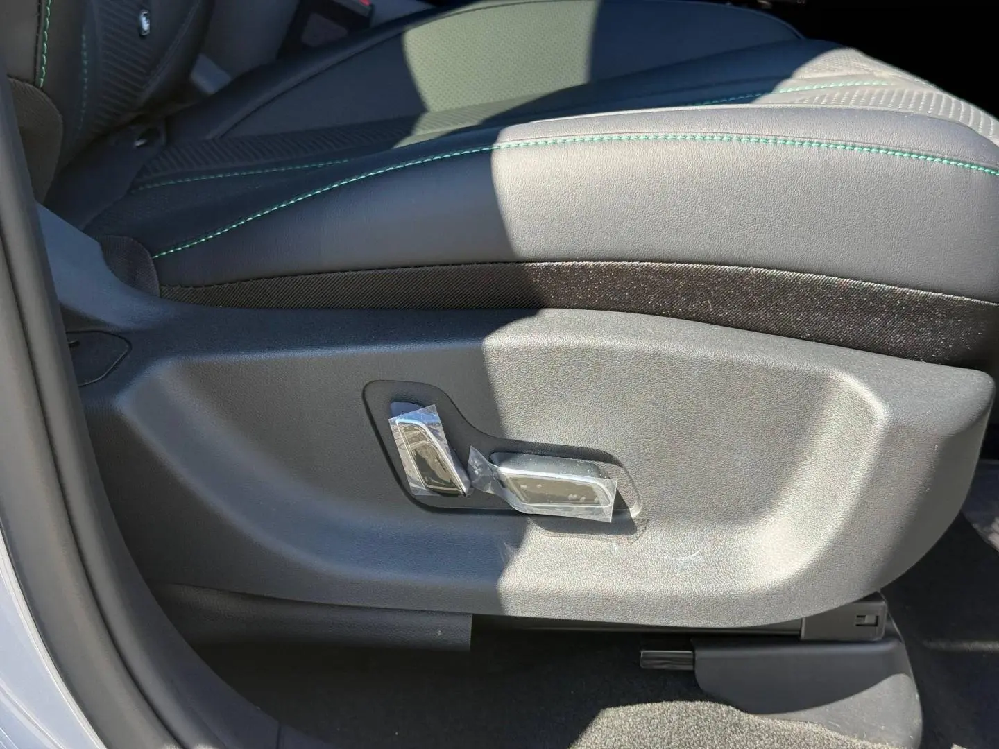 Détail du réglage électrique du siège conducteur noir avec surpiqûres vertes dans un BYD SEAL U 2026.