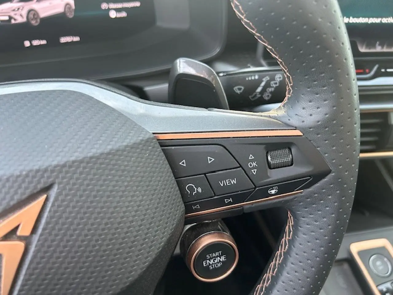 Gros plan sur le volant cuir perforé côté droit du CUPRA Formentor blanc neige avec bouton Start Engine Stop visible.