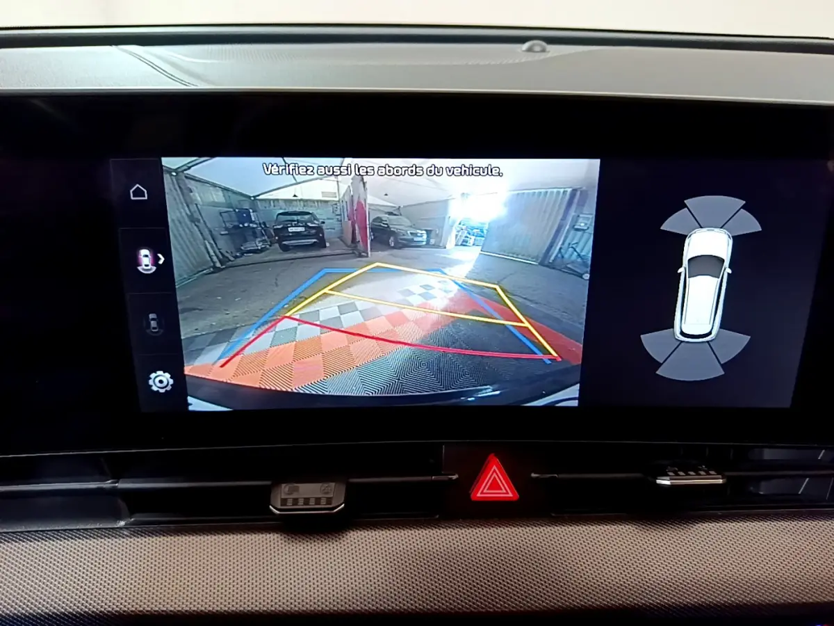 Affichage de la caméra de recul et aide au stationnement sur écran tactile du Kia Sportage blanc 2022, vue intérieure.