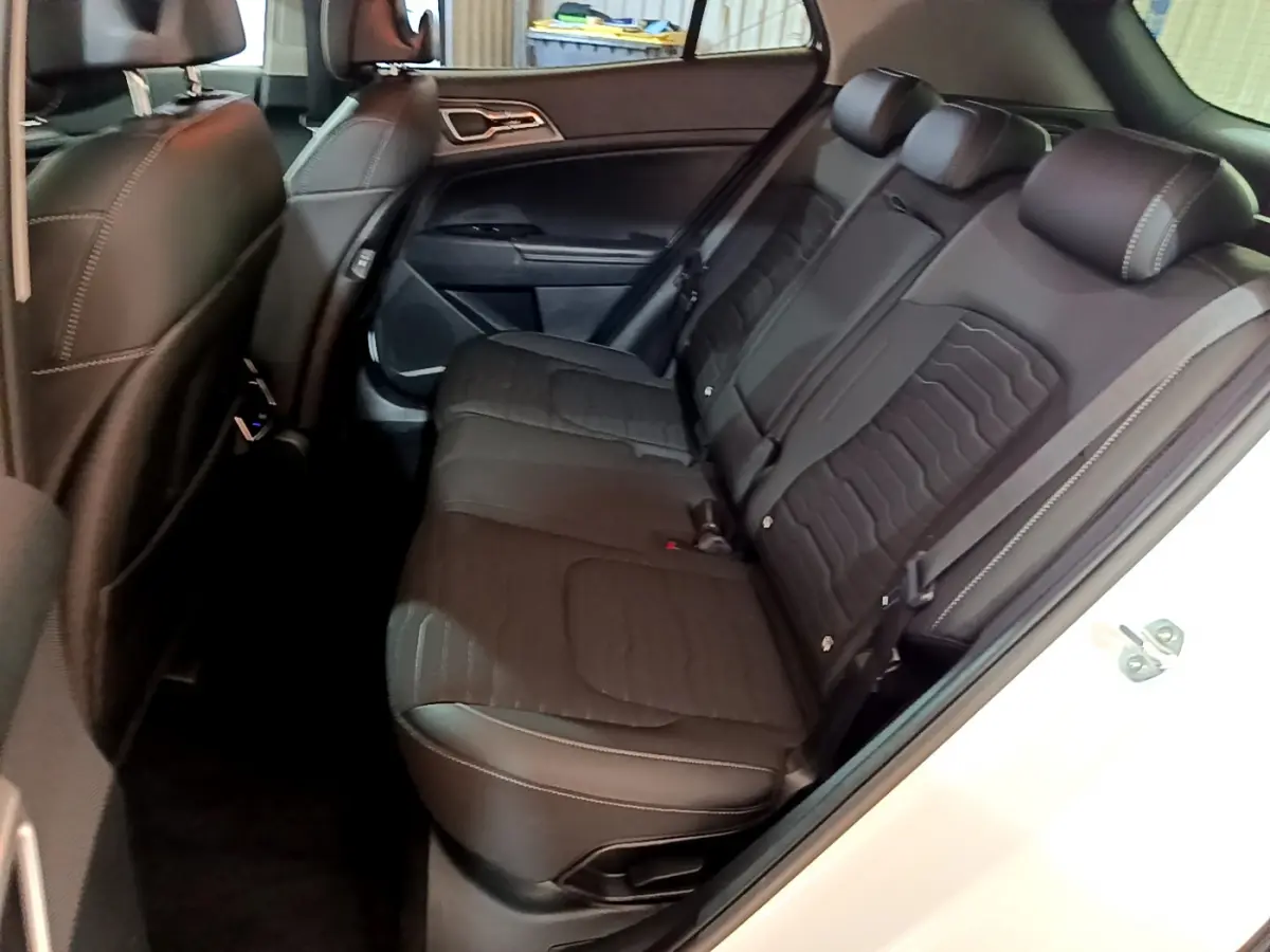 Vue côté droit sur la banquette arrière noire du Kia Sportage blanc 2022 avec surpiqûres contrastées.