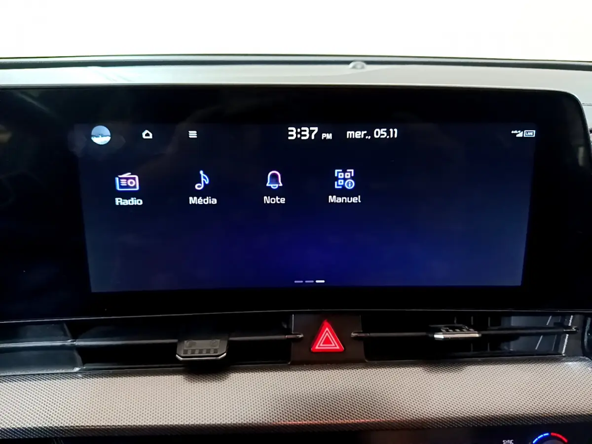 Écran tactile central allumé du tableau de bord du KIA SPORTAGE blanc, affichant les options Radio, Média, Note et Manuel.