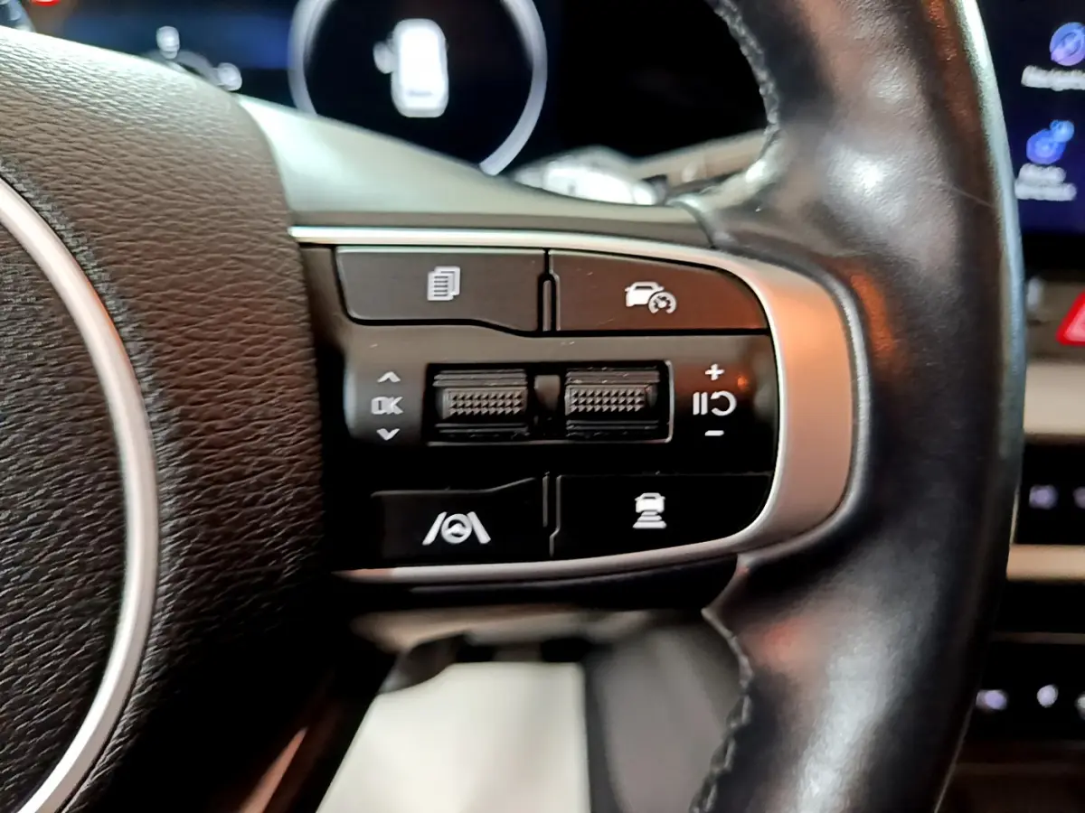 Gros plan sur les commandes multifonctions côté droit du volant cuir du KIA SPORTAGE blanc 2022 hybride rechargeable.