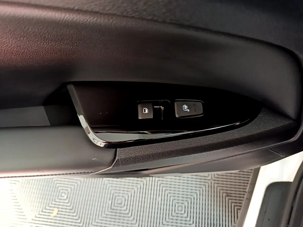 Gros plan sur les commandes de verrouillage et siège chauffant côté conducteur du KIA Sportage blanc 2022.