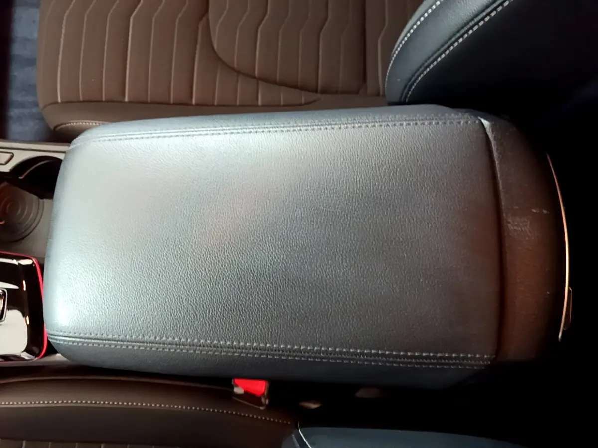 Accoudoir central noir en cuir vu de dessus dans l'habitacle du Kia Sportage blanc hybride 2022