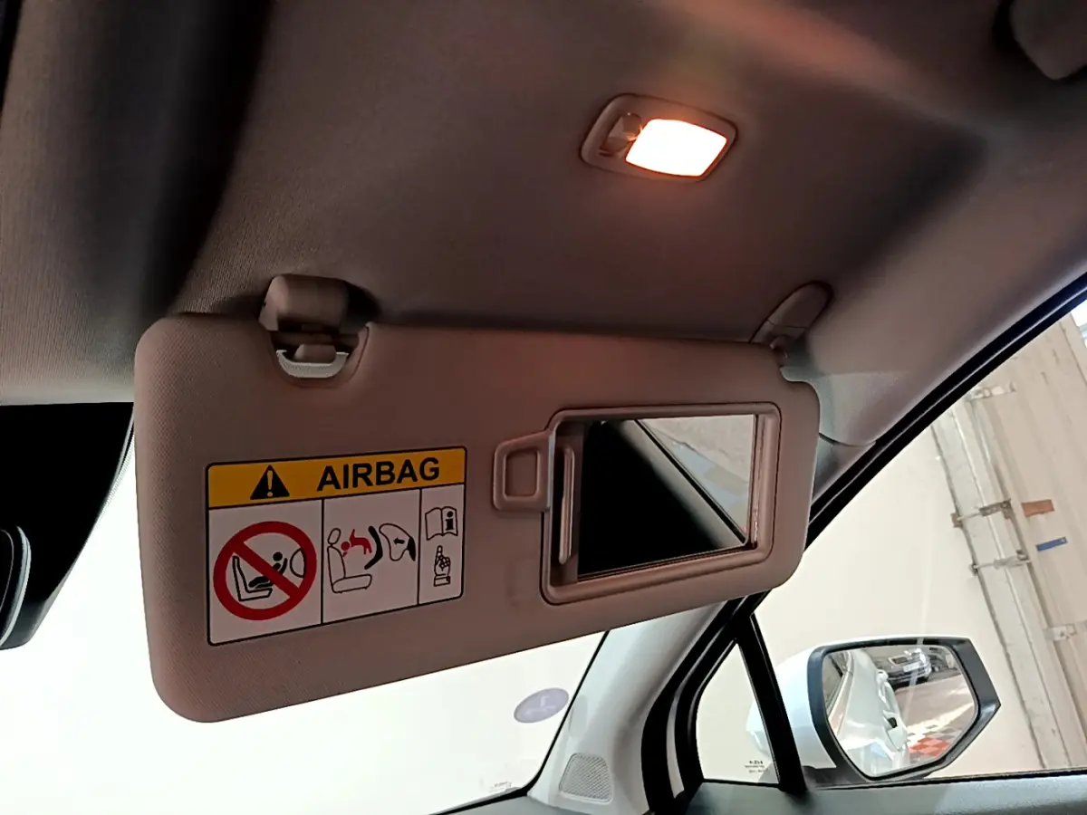 Miroir de pare-soleil côté conducteur avec avertissement airbag, intérieur clair du Kia Sportage blanc 2022.
