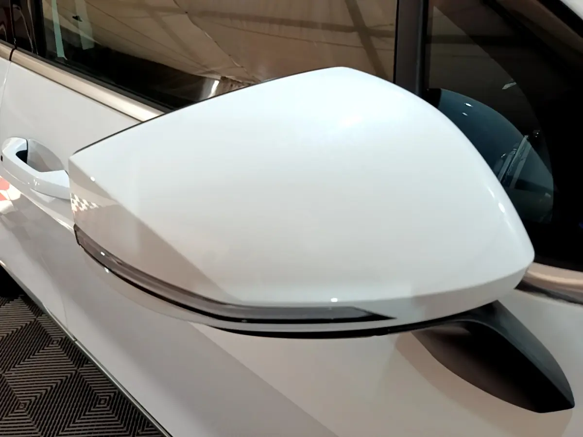 Gros plan sur le rétroviseur droit blanc du KIA SPORTAGE 2022 hybride rechargeable, avec clignotant intégré.