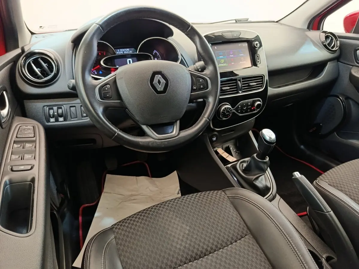 Vue intérieure avant de la Renault Clio Intens 2018, montrant le volant cuir, écran tactile 7 pouces et levier de vitesses manuel.