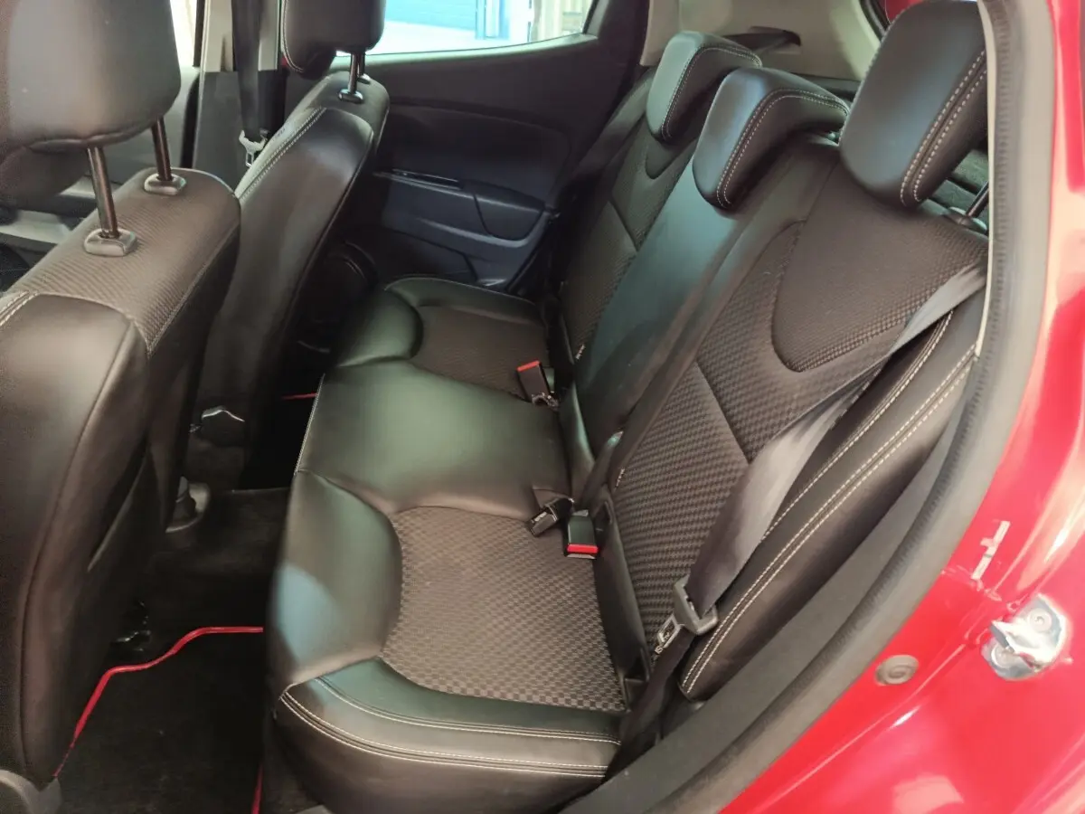 Vue intérieure côté droit des sièges arrière noirs en cuir et tissu d'une Renault Clio Intens rouge de 2018.