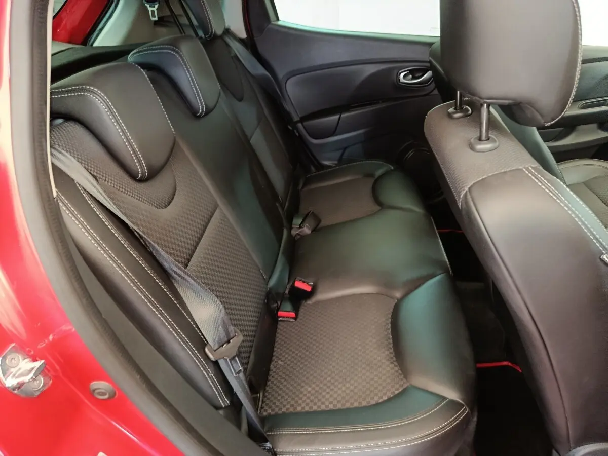 Vue intérieure côté gauche montrant la banquette arrière en cuir noir de la Renault Clio rouge 2018.