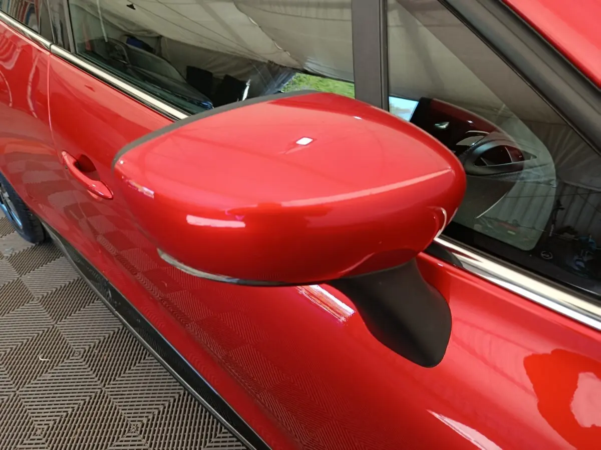 Gros plan sur le rétroviseur droit rouge brillant de la Renault Clio Intens Energy TCe 90 de 2018.