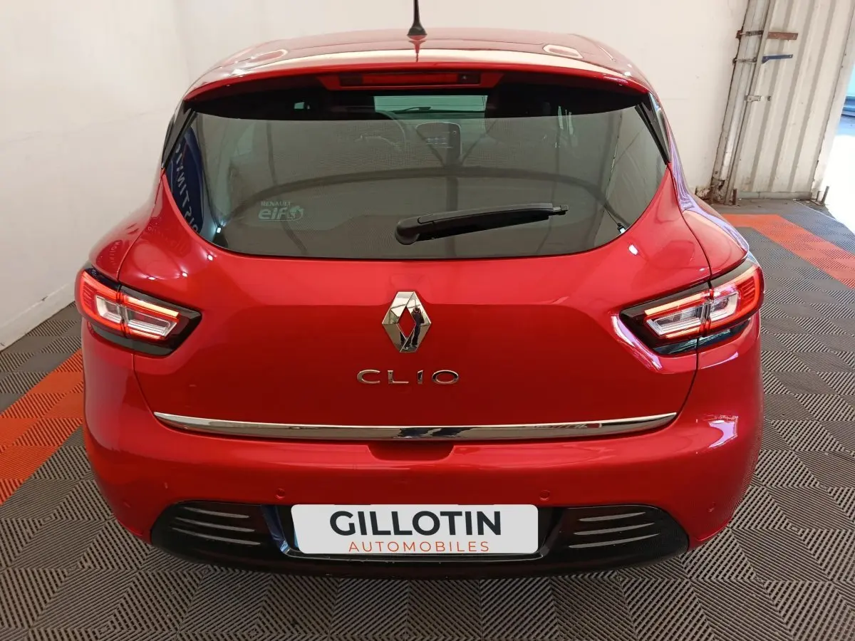 Vue arrière d'une Renault Clio rouge 2018 avec feux LED et logo chromé bien visibles.