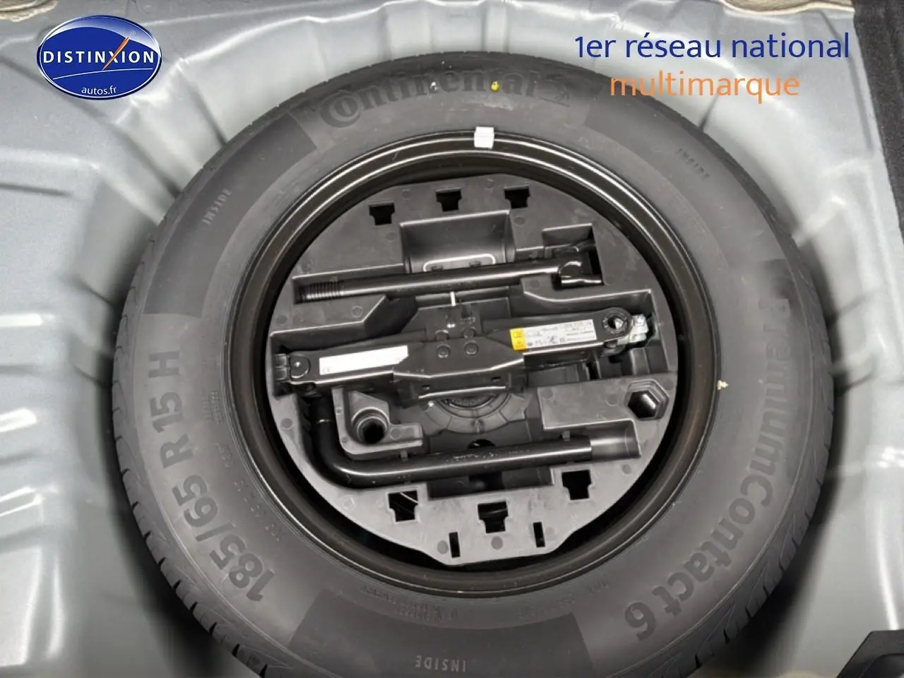 Vue plongeante sur la roue de secours et le kit de réparation dans le coffre d'une Renault Clio V noire 2026.