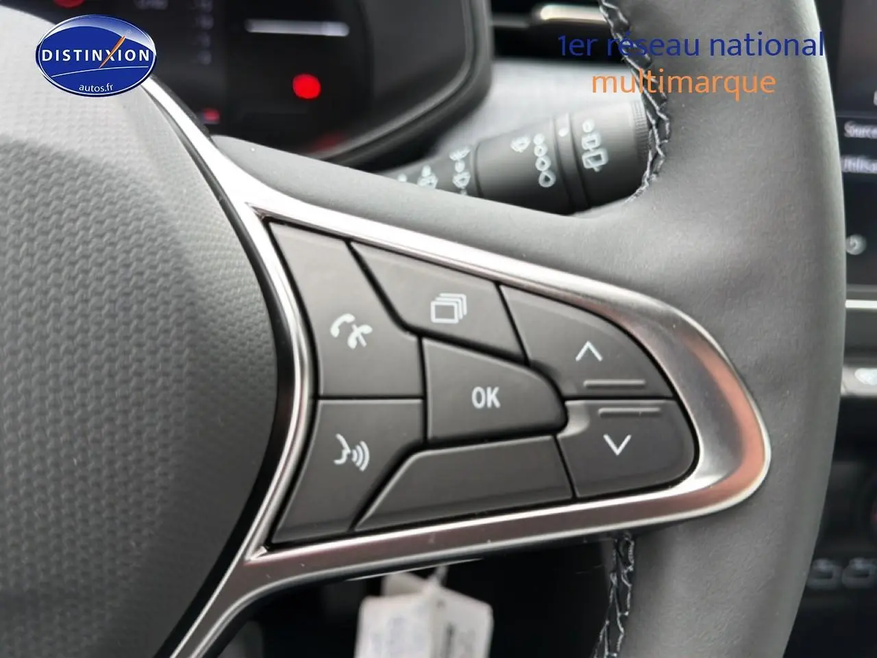 Gros plan sur les commandes multifonctions du volant cuir noir de la Renault Clio V 1.0 TCe 90 Evolution.