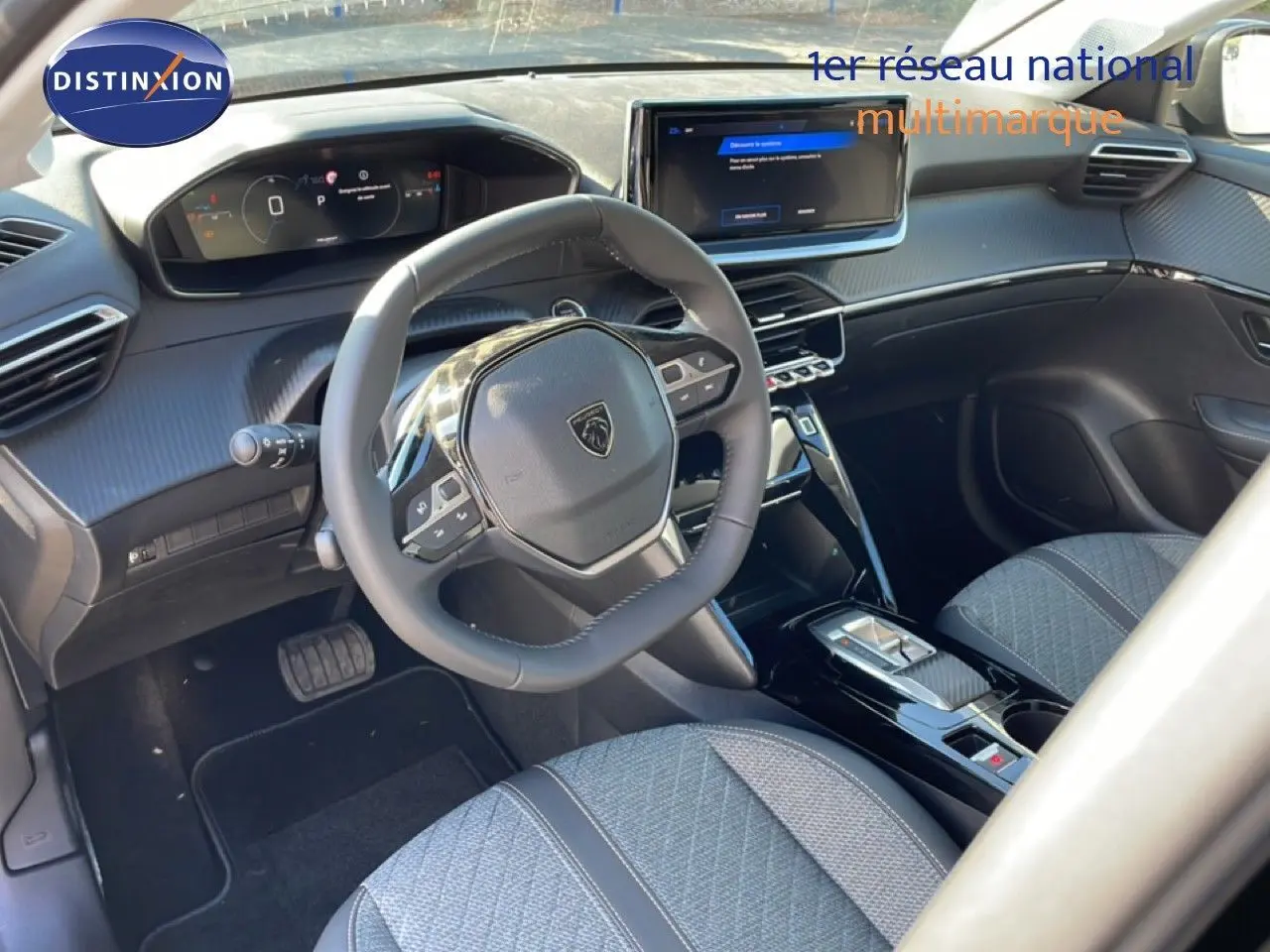 Intérieur de la Peugeot 208 Hybrid 110ch 2026 vu côté conducteur, volant compact et tableau de bord numérique.
