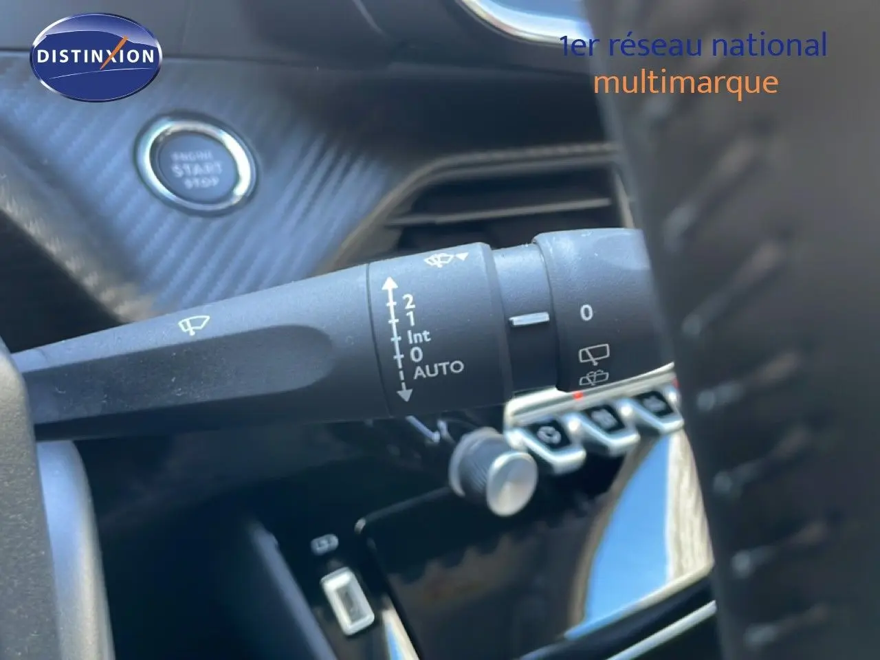 Gros plan sur la commande d’essuie-glace à gauche du volant dans l’habitacle noir de la Peugeot 208 Hybrid 110ch 2026.