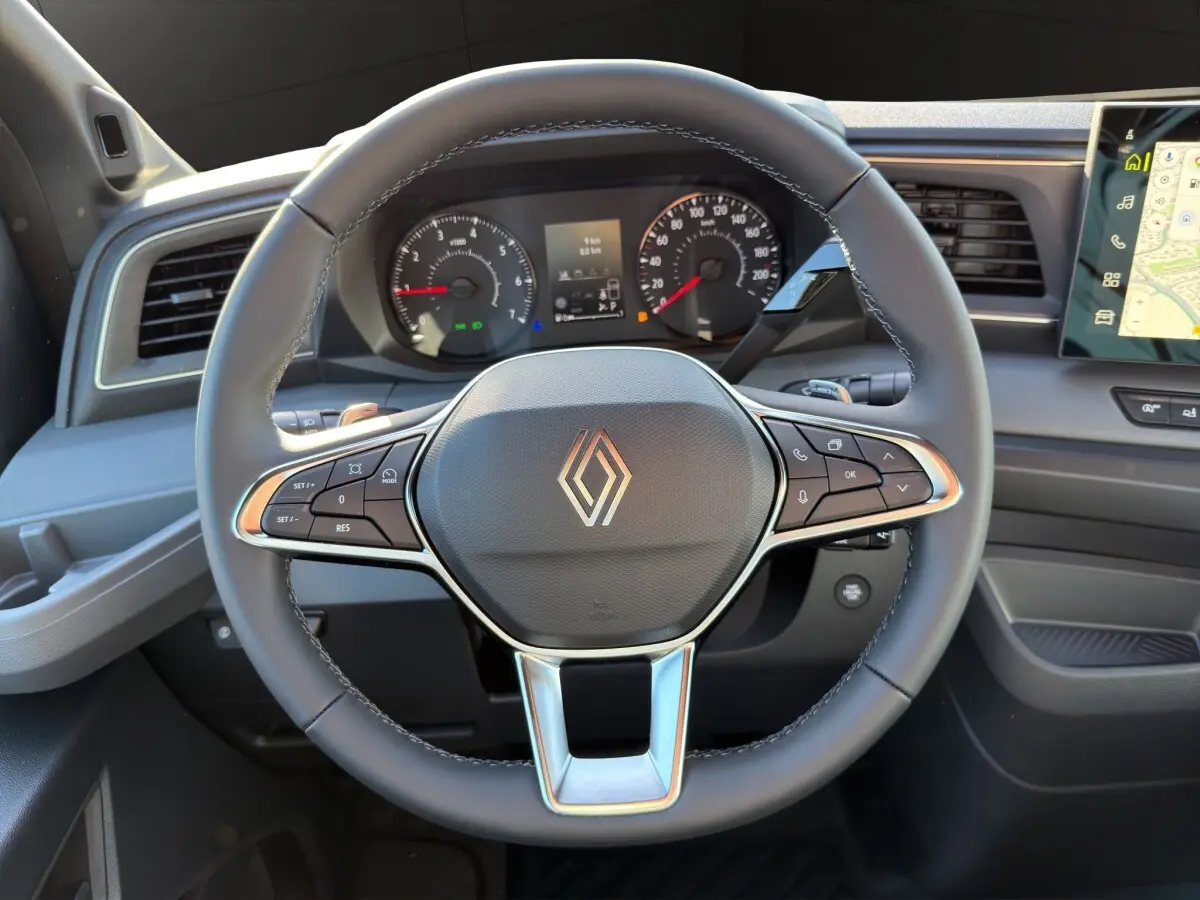 Vue rapprochée du volant noir du Renault Master 2026 avec tableau de bord et écran tactile de navigation visible.