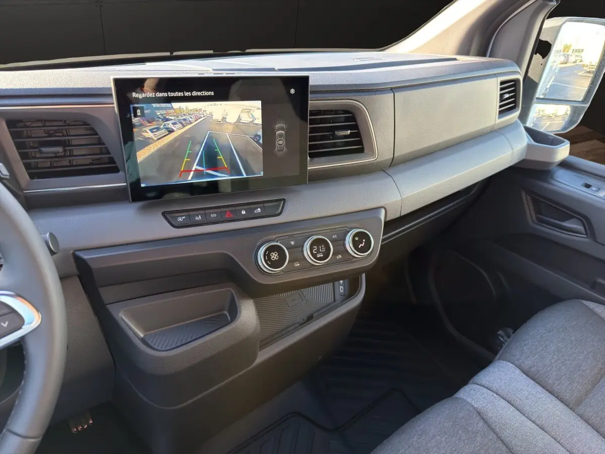 Vue intérieure côté passager du tableau de bord du Renault Master 2026 avec écran tactile et commandes de climatisation.