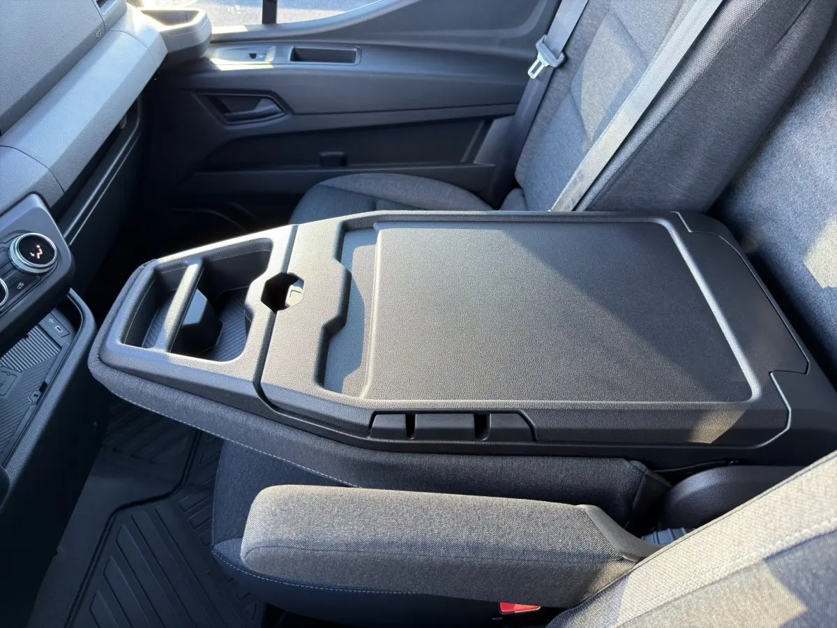 Vue intérieure rapprochée du siège passager gris avec tablette rabattable et porte-gobelets du Renault Master blanc 2026.