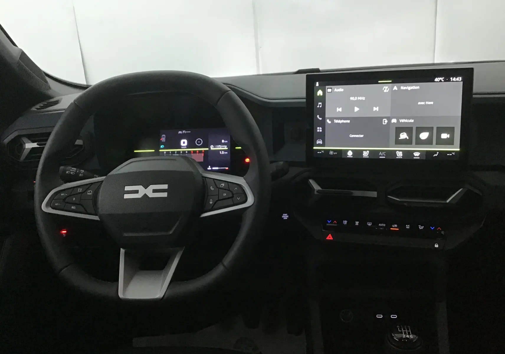 Vue intérieure du tableau de bord du Dacia Bigster 2025, avec volant multifonction, écran tactile central et levier de vitesses manuel.