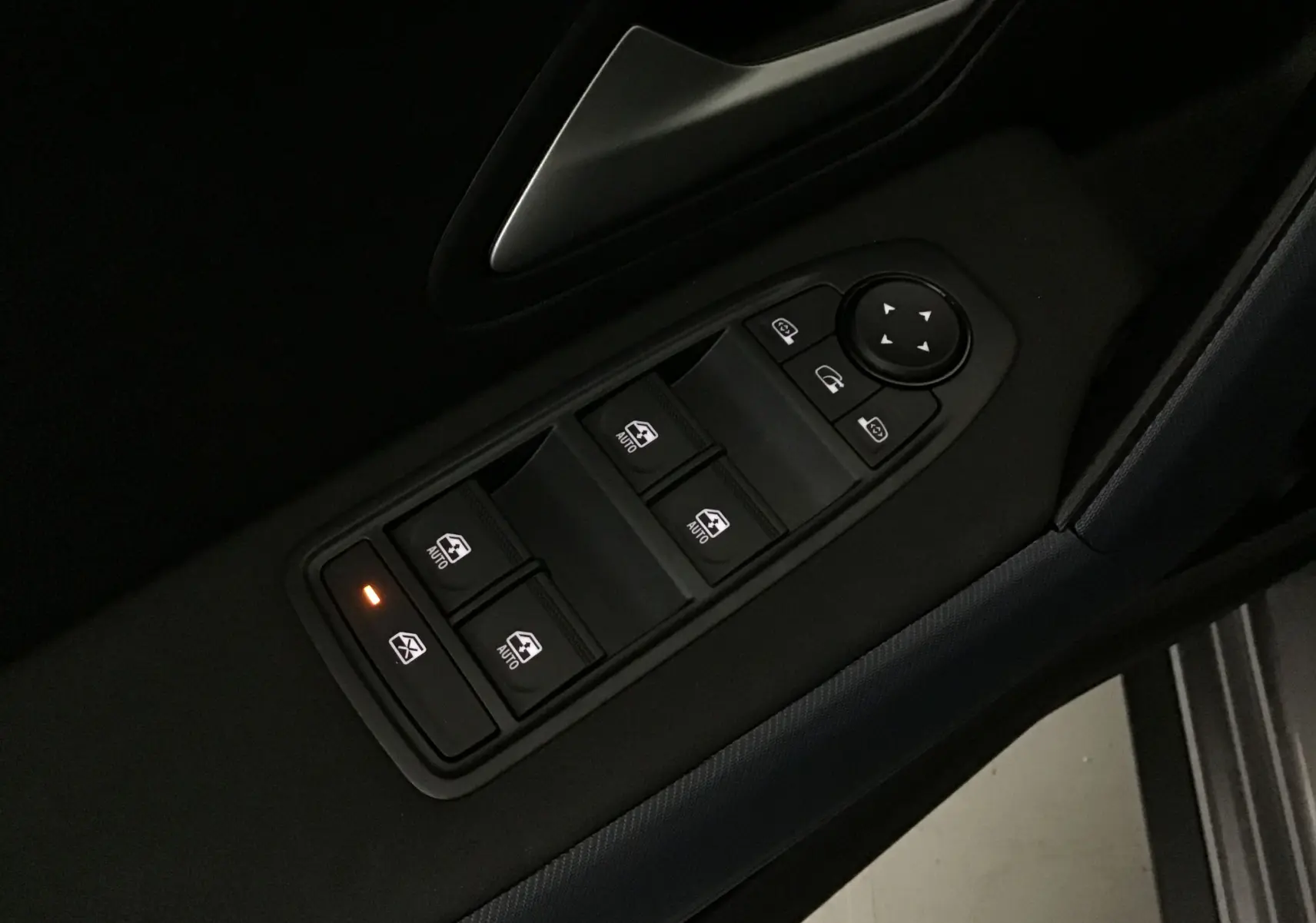 Panneau de commandes des vitres électriques côté gauche dans une Dacia Bigster gris schiste, avec verrouillage activé.