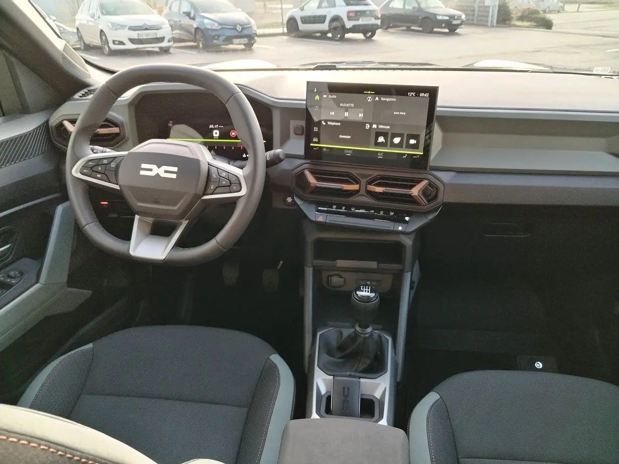 Intérieur du Dacia Bigster 2025 en vue frontale, avec tableau de bord moderne et écran tactile central.