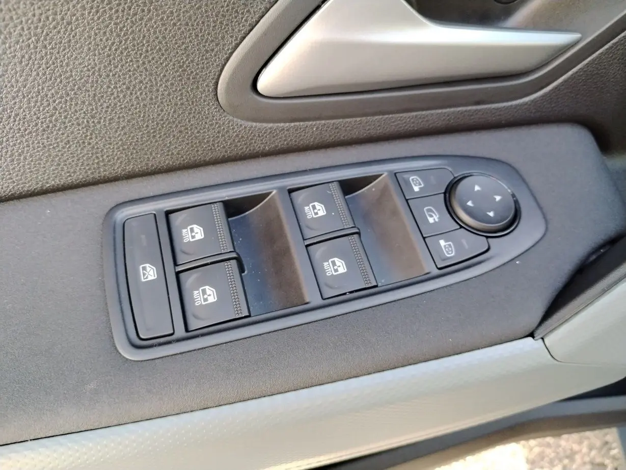 Panneau de commande des vitres électriques côté conducteur du Dacia Bigster noir, avec boutons de verrouillage et réglage des rétroviseurs.