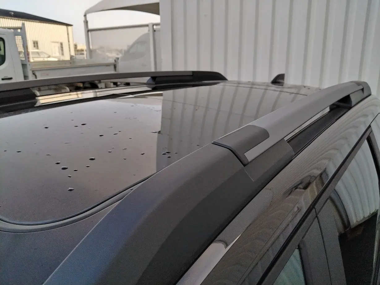 Gros plan sur le toit noir du Dacia Bigster 2025 avec barres de toit et gouttes de pluie visibles.