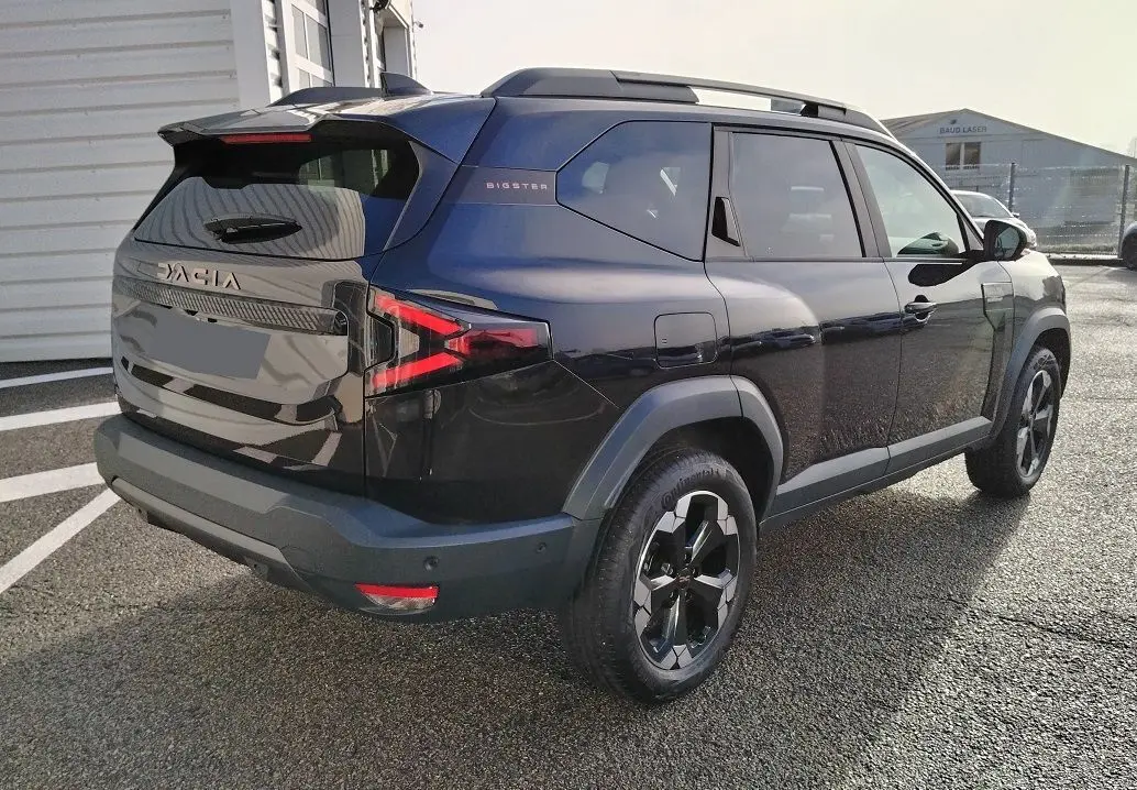 Vue 3/4 arrière droite du SUV noir Dacia Bigster 2025 avec jantes noires et feux arrière LED distinctifs.