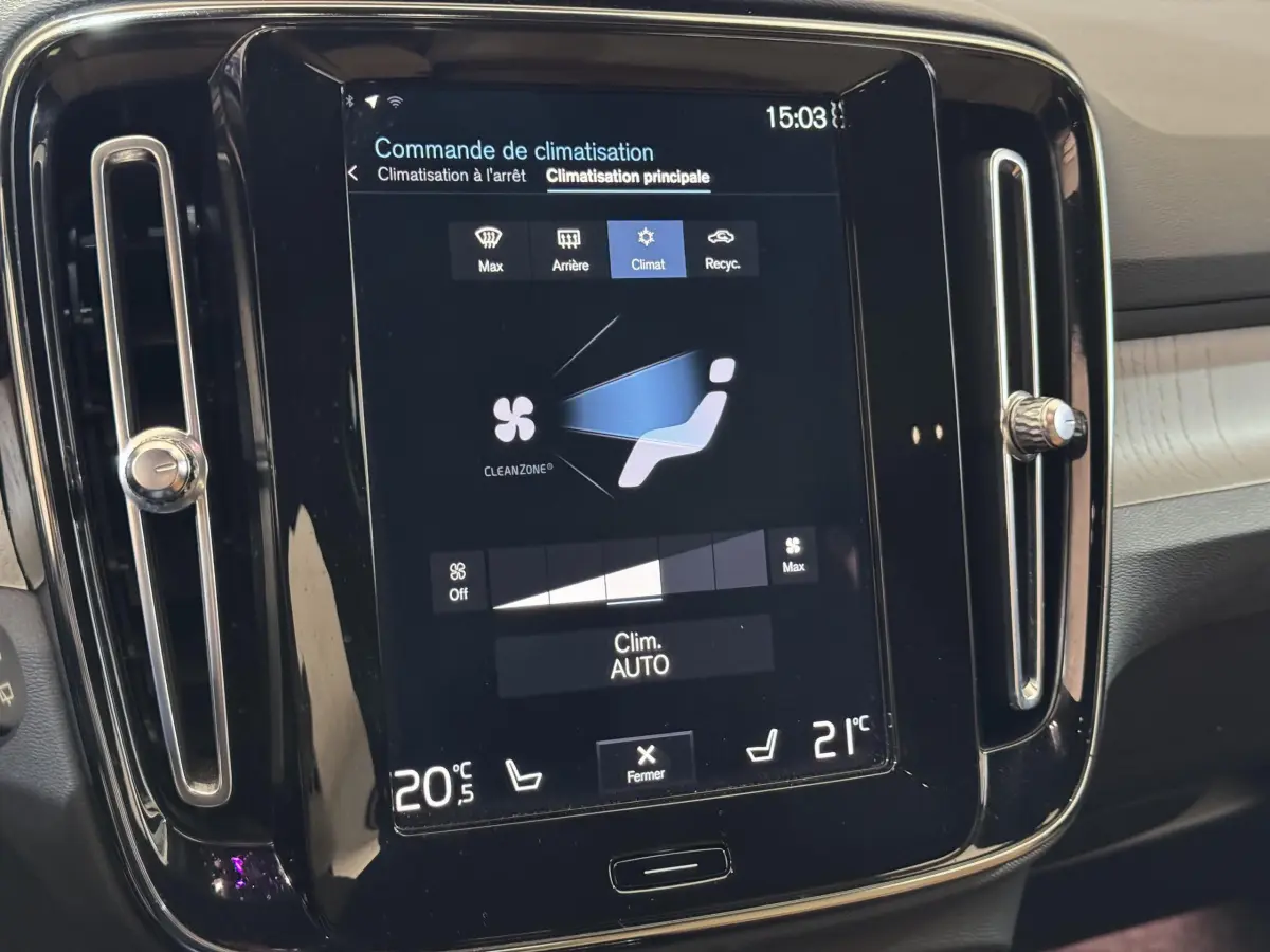 Écran tactile central affichant la commande de climatisation dans l’habitacle clair d’un Volvo XC40 noir de 2021