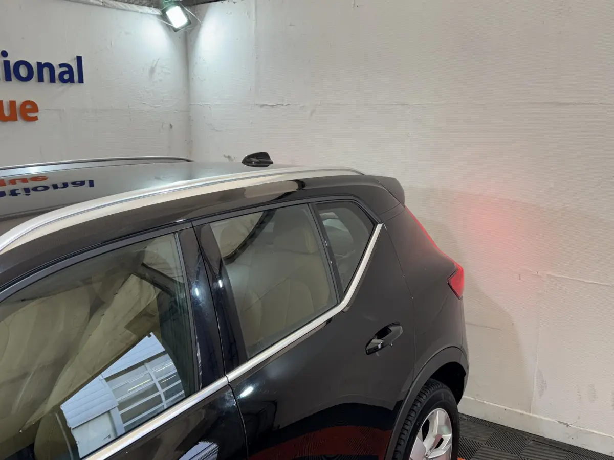 Vue latérale côté droit du Volvo XC40 Recharge T5 noir, mettant en valeur la ligne de toit et les vitres teintées.