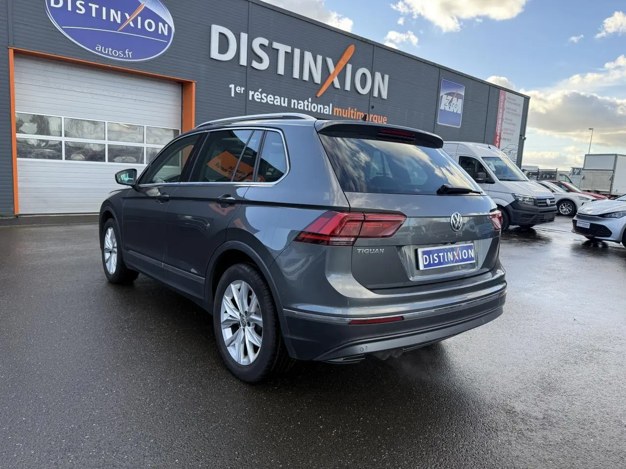 Volkswagen Tiguan gris Indium métallisé vu en 3/4 arrière droit, avec feux arrière LED et jantes alliage 18 pouces.