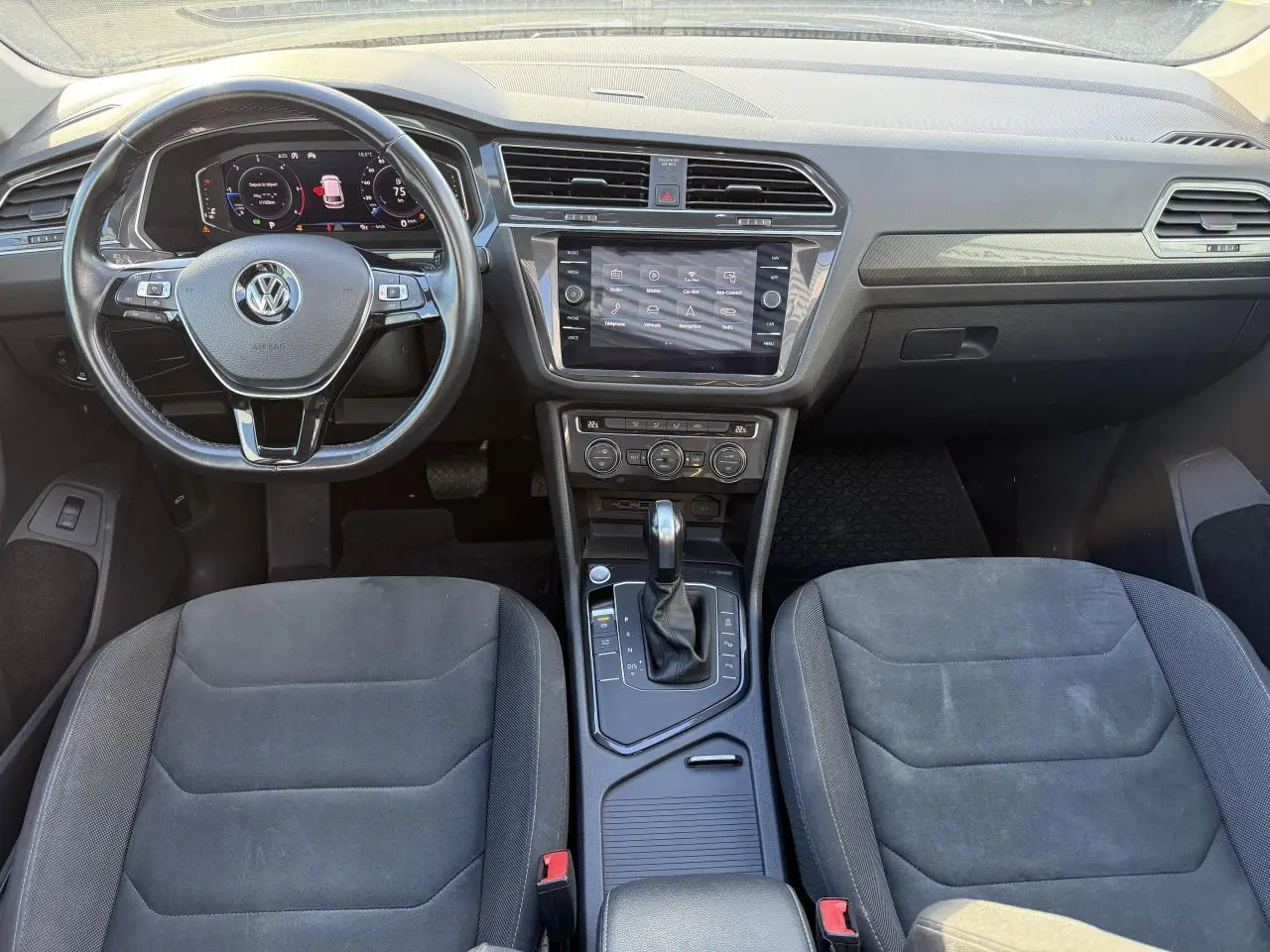 Intérieur du Volkswagen Tiguan 2020 en vue frontale, montrant le volant multifonctions et la console centrale noire.