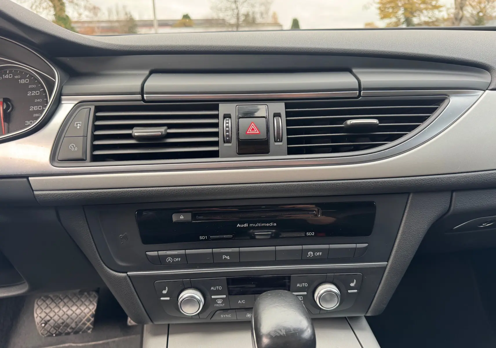 Vue rapprochée du tableau de bord noir de l'Audi A6 Avant 2015, mettant en valeur la console centrale et les aérateurs.