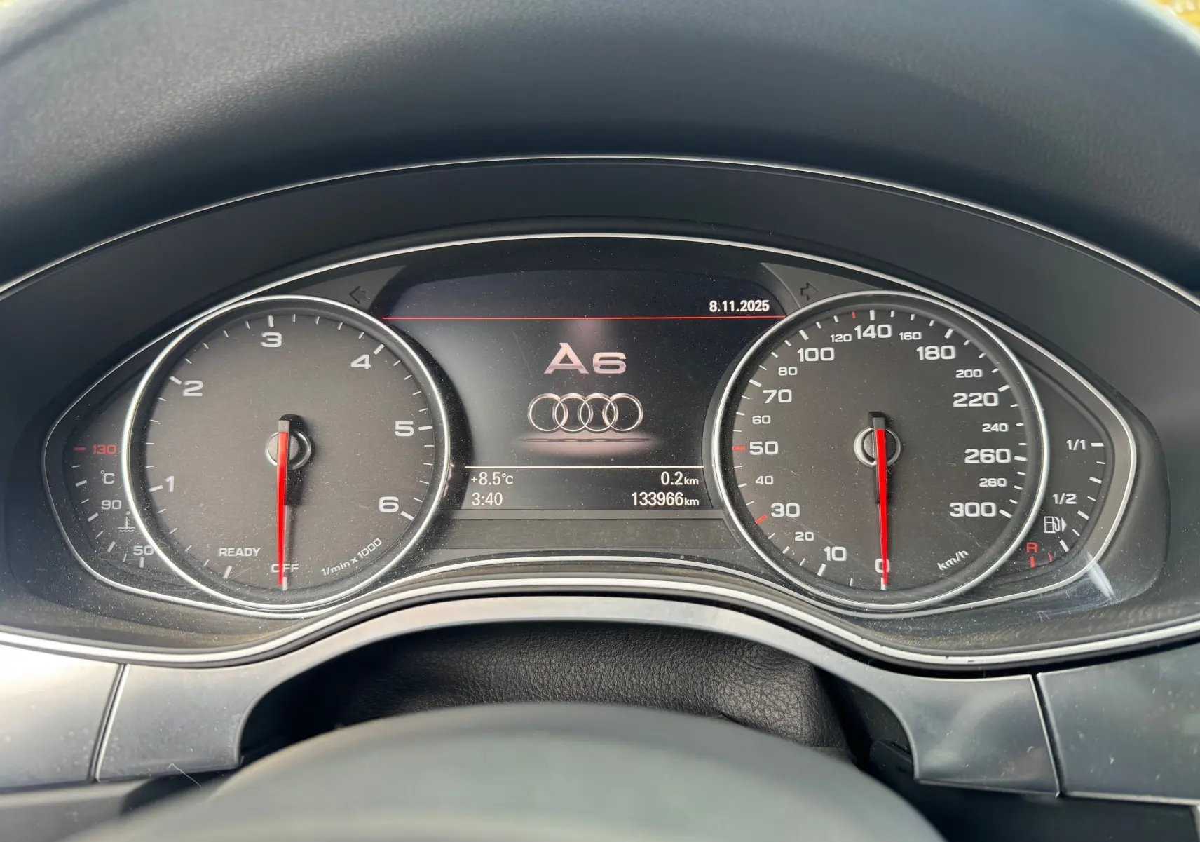 Vue rapprochée du tableau de bord numérique de l'Audi A6 Avant 2015, affichant compte-tours, vitesse et logo central.