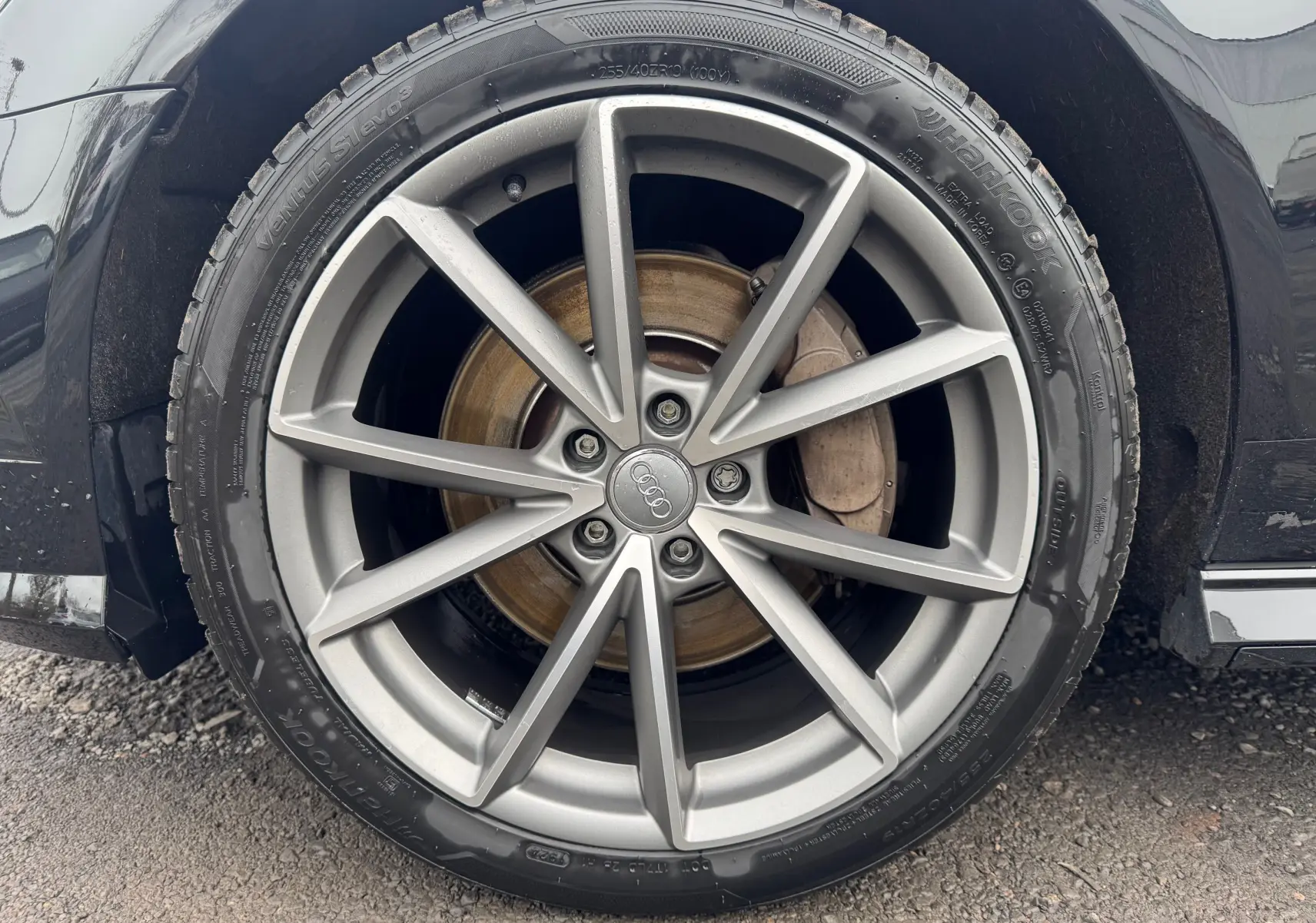 Gros plan sur la jante alliage grise et le pneu Hankook d’une Audi A6 Avant noire, côté arrière droit.