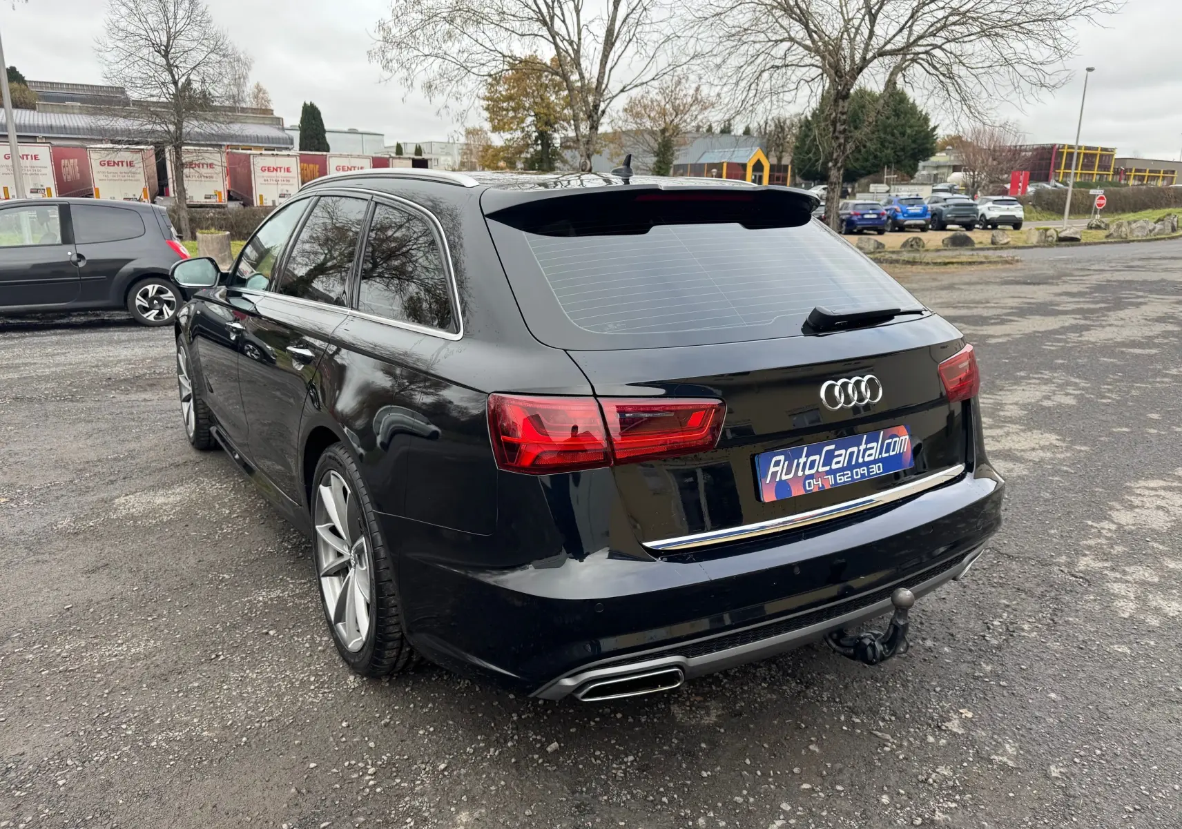 Audi A6 Avant noir vue 3/4 arrière droit, avec feux LED et attelage de remorque visible.