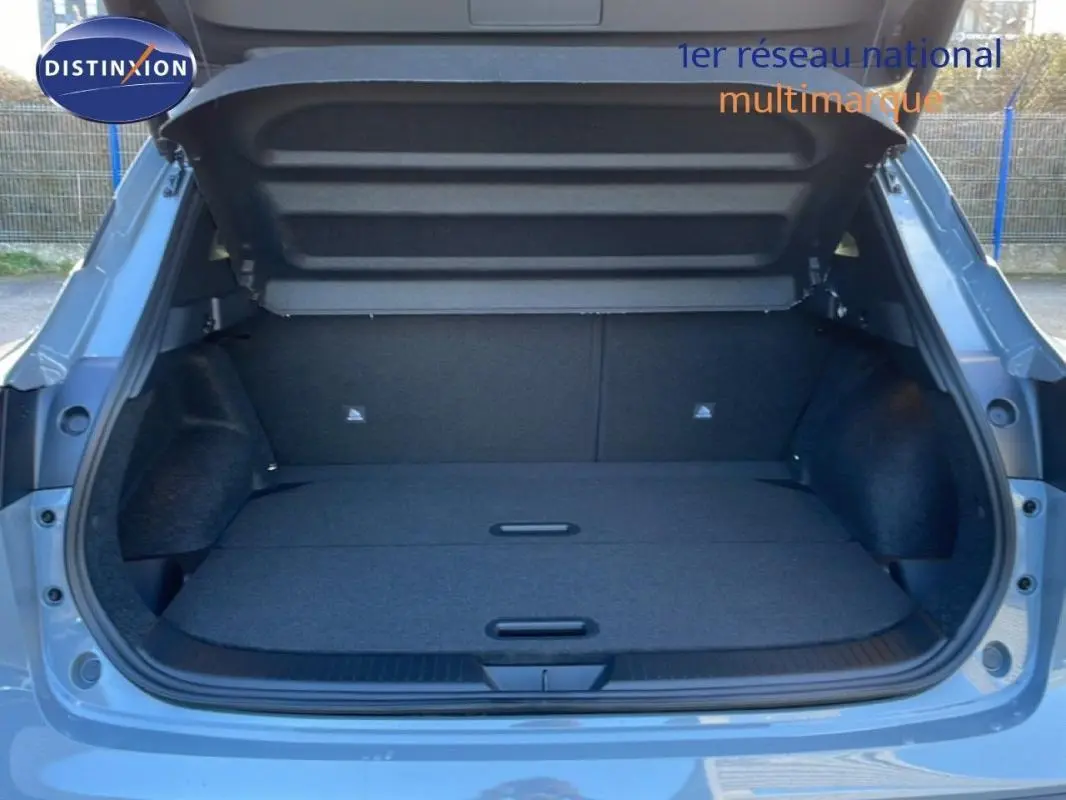 Coffre ouvert d’un Nissan Qashqai gris 2025, vue arrière montrant un espace de chargement plat et spacieux.