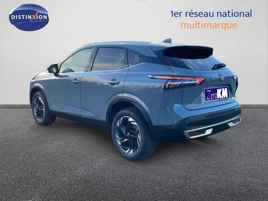 Vue 3/4 arrière droite du Nissan Qashqai gris 2025 avec jantes aluminium et feux arrière LED allumés.