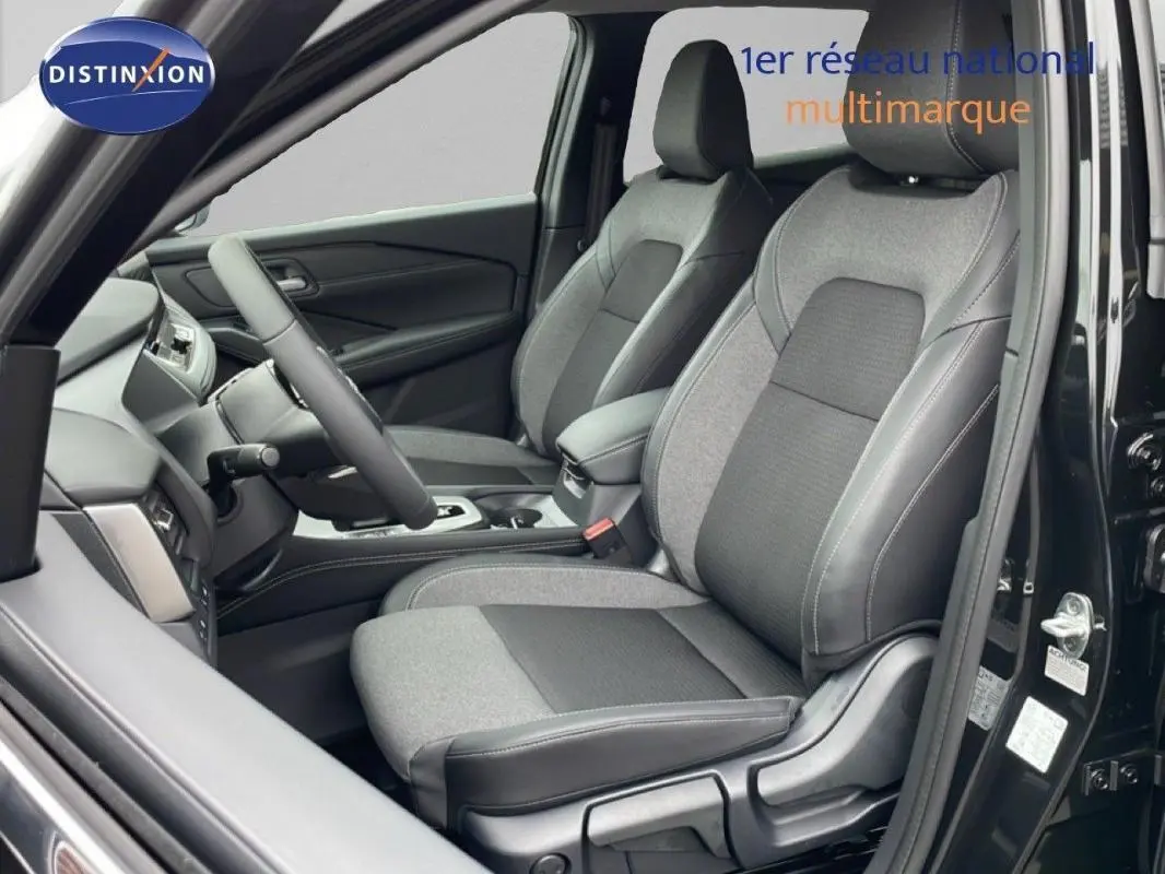 Vue intérieure côté conducteur du Nissan Qashqai noir 2025, mettant en valeur les sièges en tissu bicolore et le tableau de bord moderne.