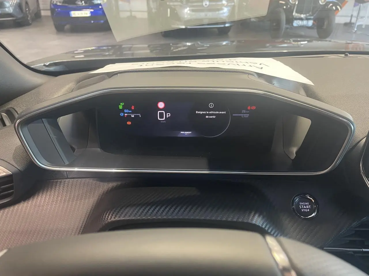 Tableau de bord numérique du Peugeot 2008 1.2i Hybrid 2026, vue frontale centrée avec bouton start/stop visible.